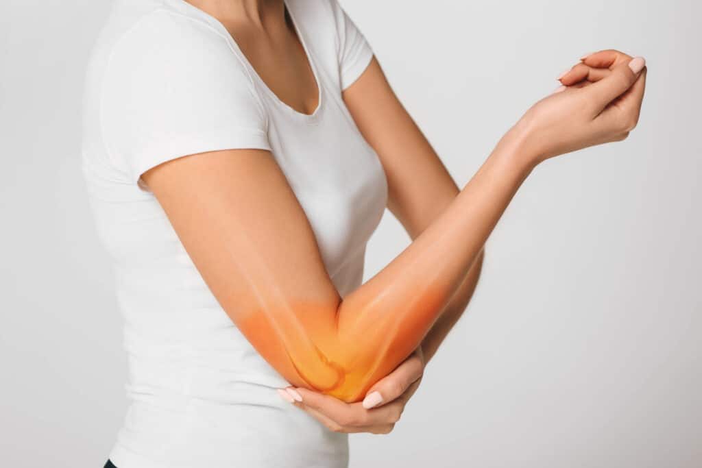 woman suffering pain in the elbow. Composite of image arm bones and elbow especially tennis elbow